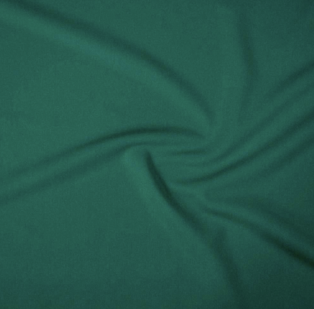 Green fabric with a swirling pattern and soft folds.