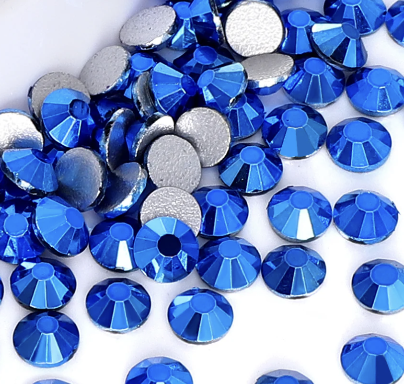 Blue and silver rhinestones scattered on a white surface.