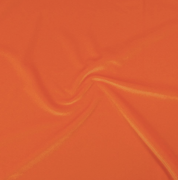 Close-up of vibrant orange fabric with a swirling pattern.