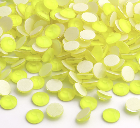 A collection of small, round, yellow and white confetti pieces scattered on a white surface.