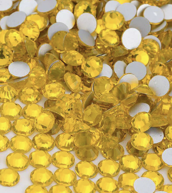 Close-up of numerous yellow rhinestones and small white circular backings.