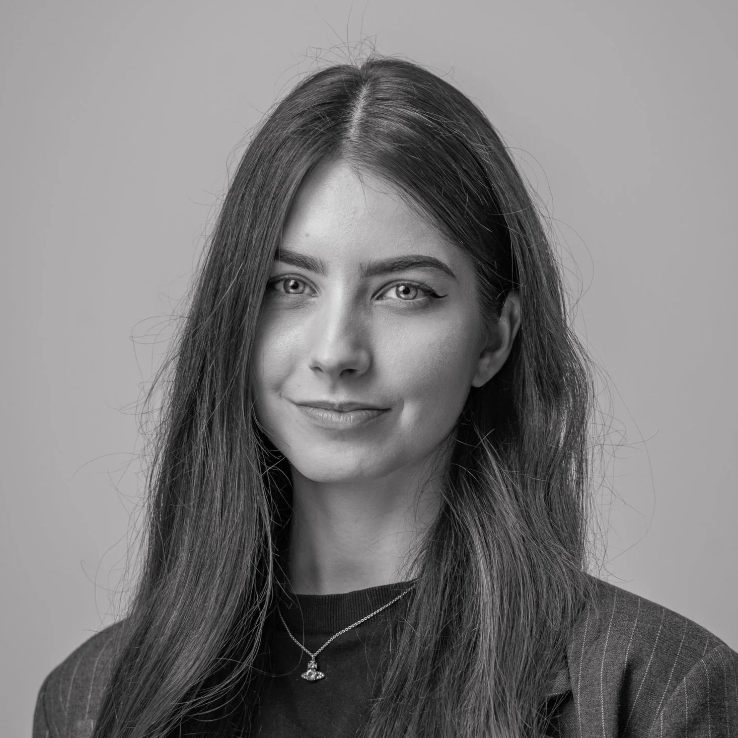 Black and white portrait of a woman with long hair, looking at the camera with a slight smile.