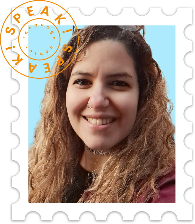A young woman with curly hair smiling, wearing a choker necklace, in front of a blue background, styled as a postage stamp with a decorative border.