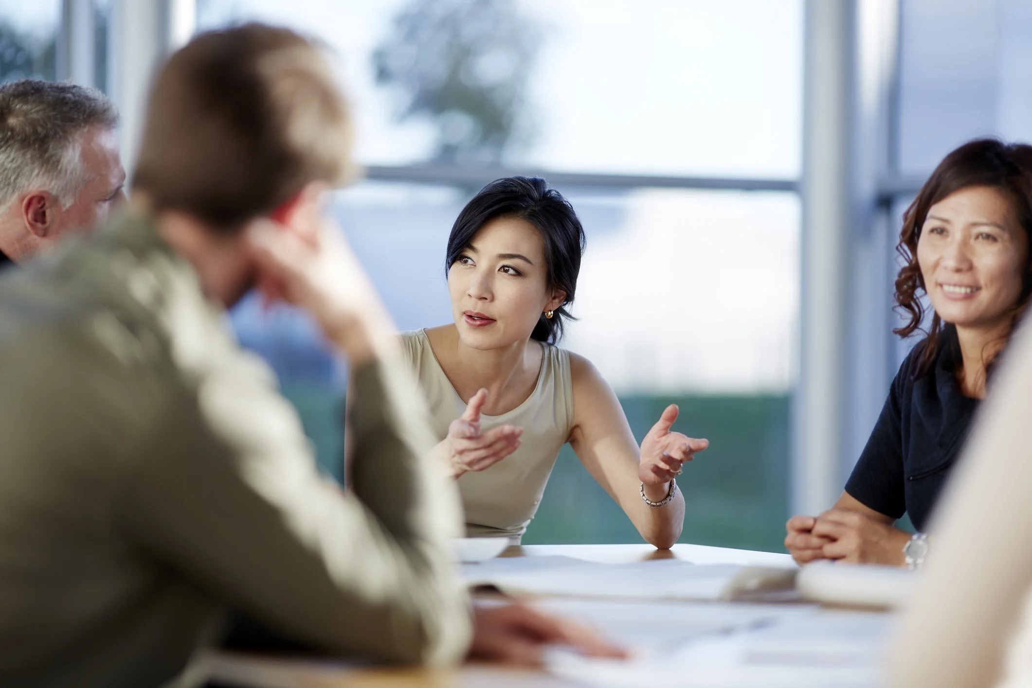 Five people discussing a topic around a table.