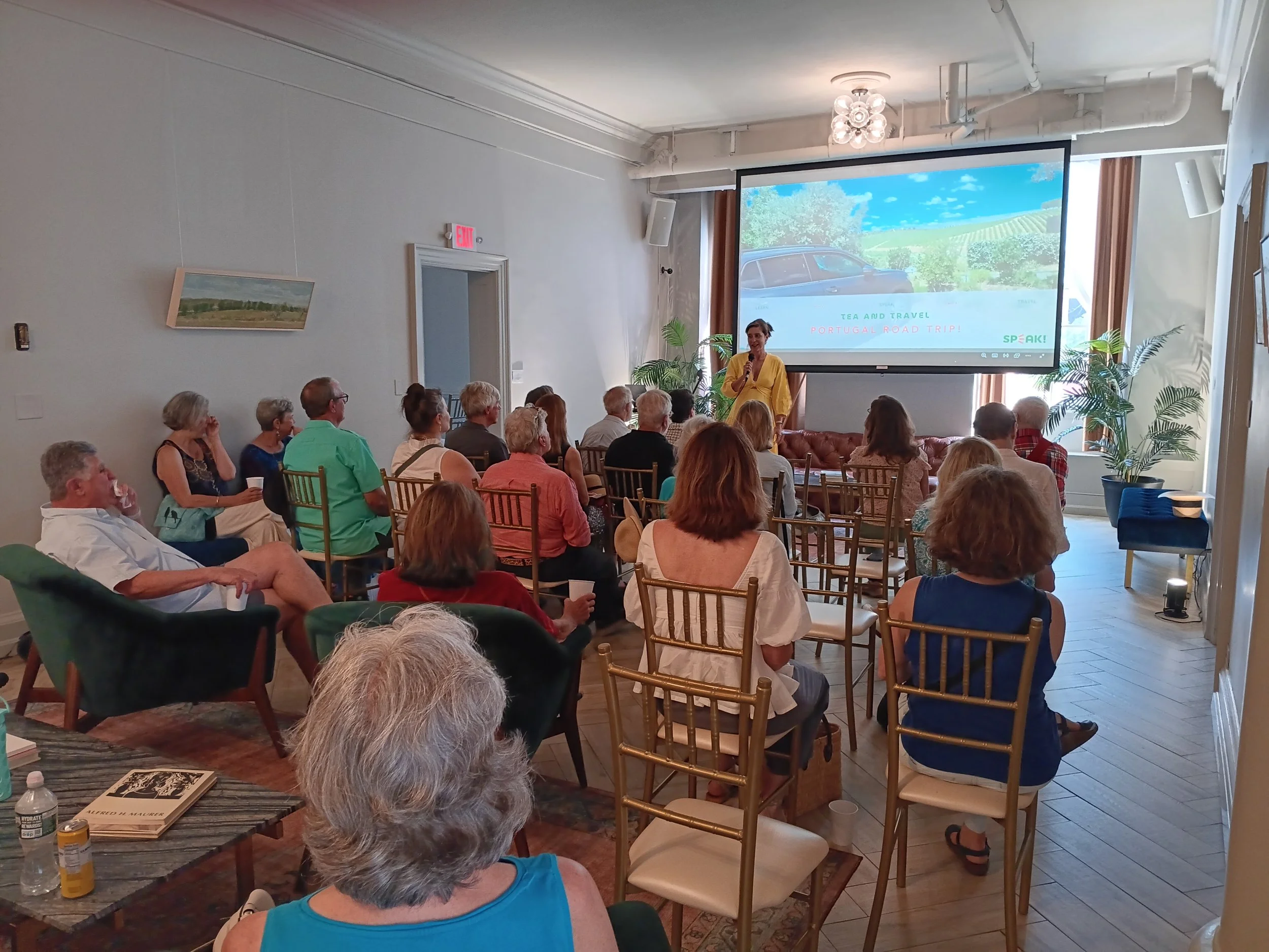 A woman presenting to a seated audience.