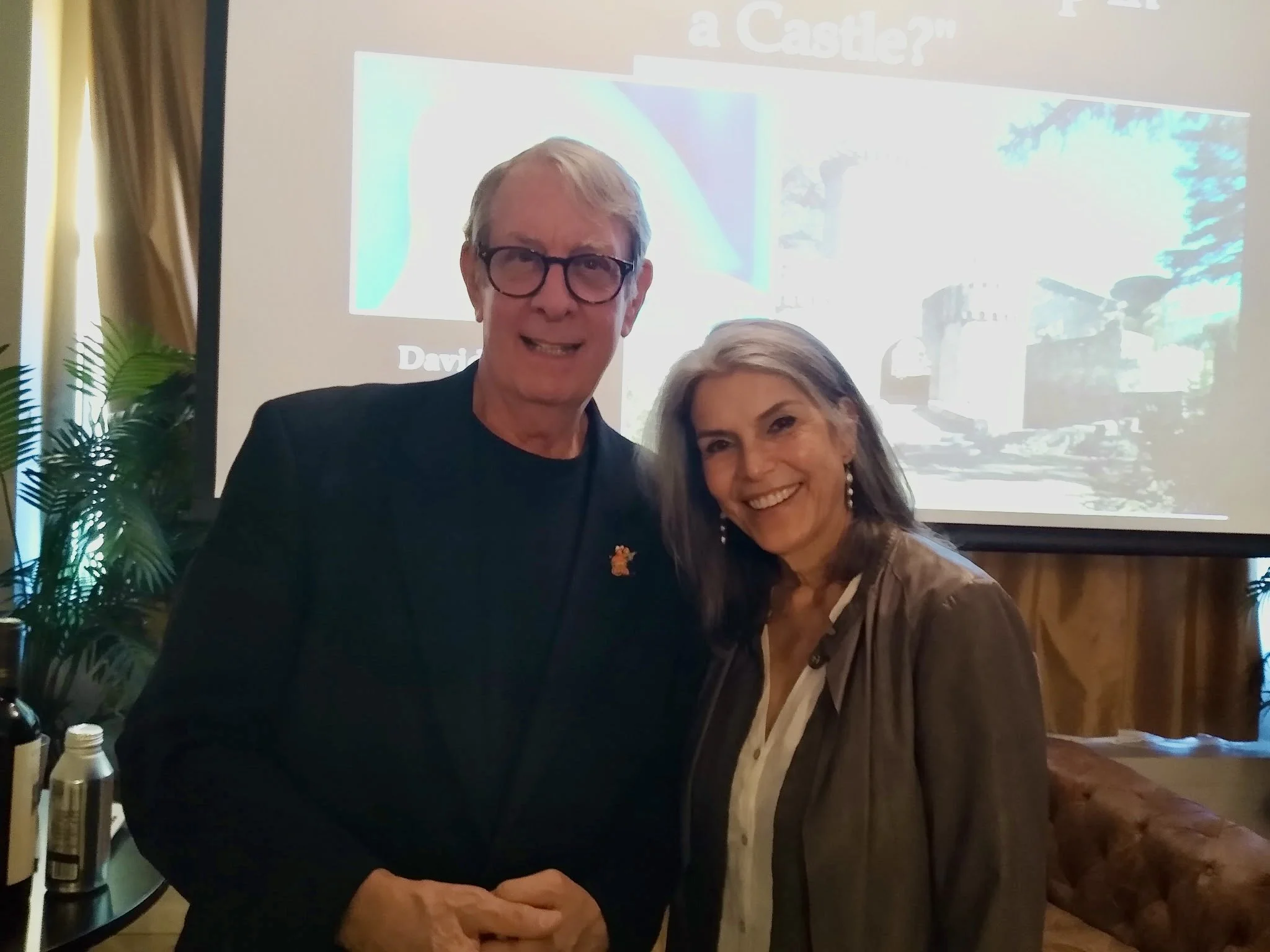 Two people smiling together at a presentation.