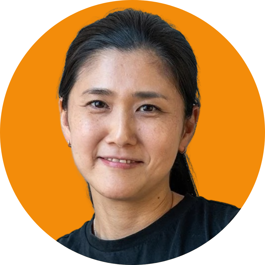 Portrait of a smiling woman on an orange background.