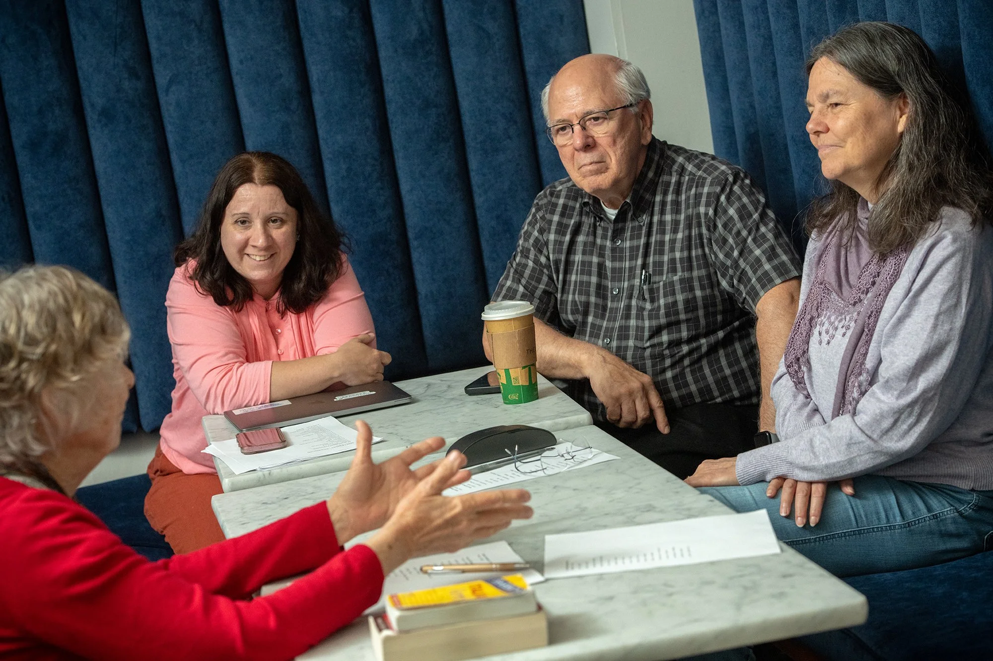 Five adults discussing a topic around a table.