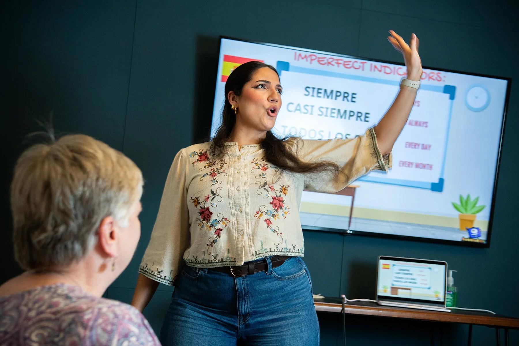 A woman giving a presentation to a seated audience.