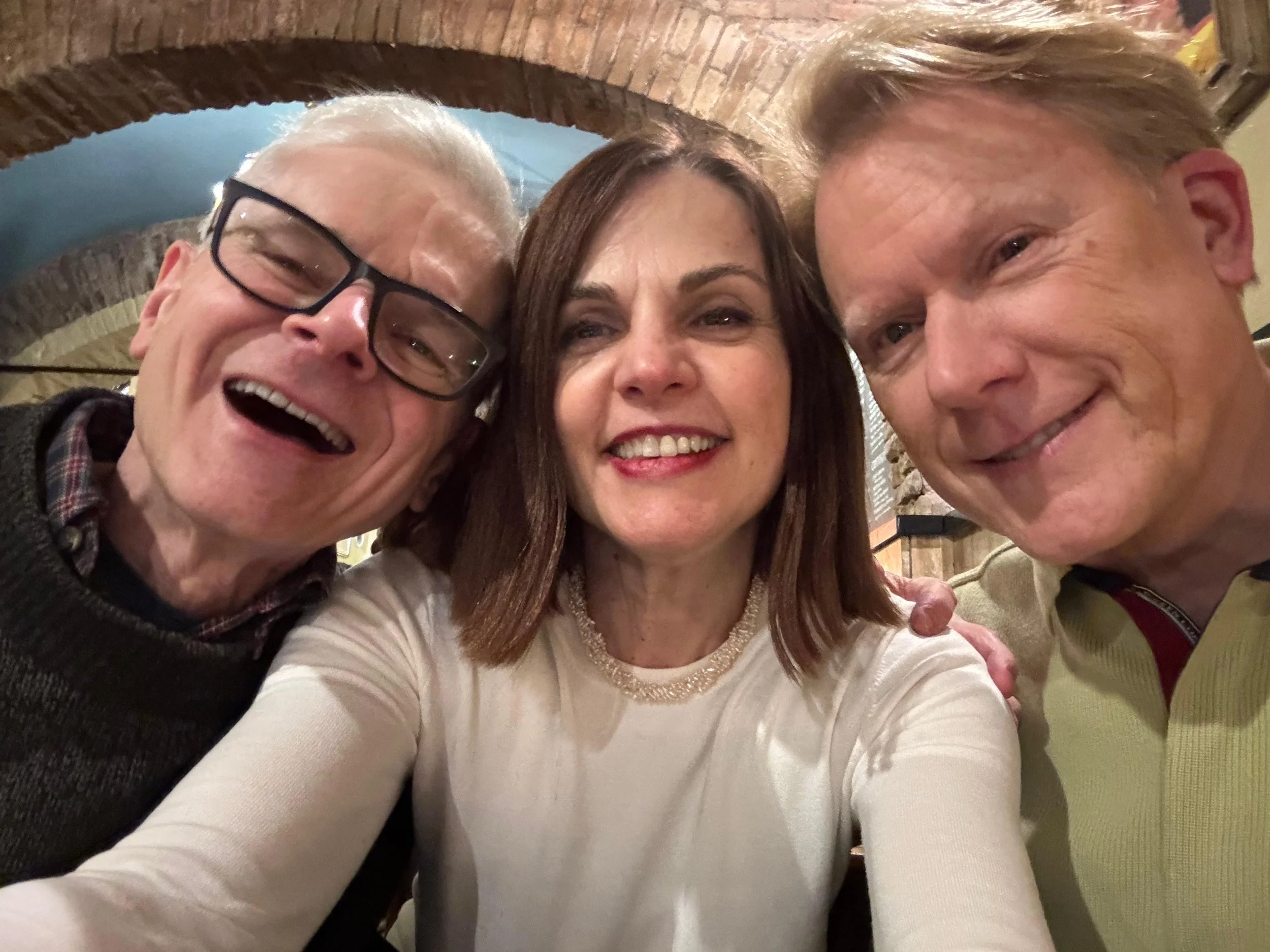 Three people taking a selfie in a restaurant.