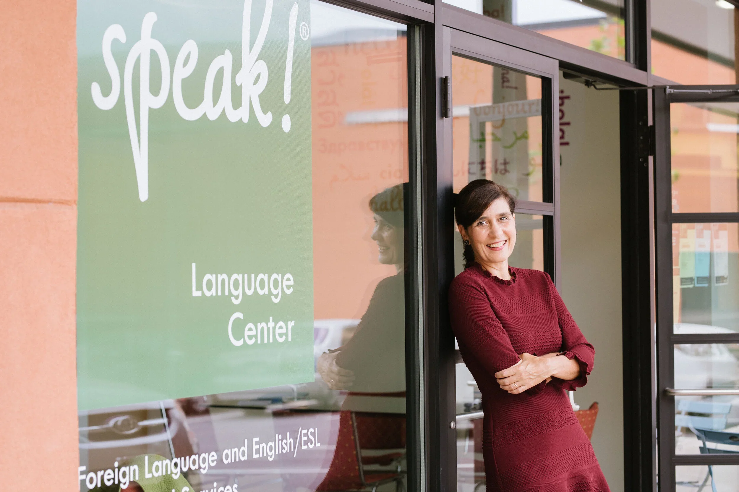 A woman smiling outside a language center.