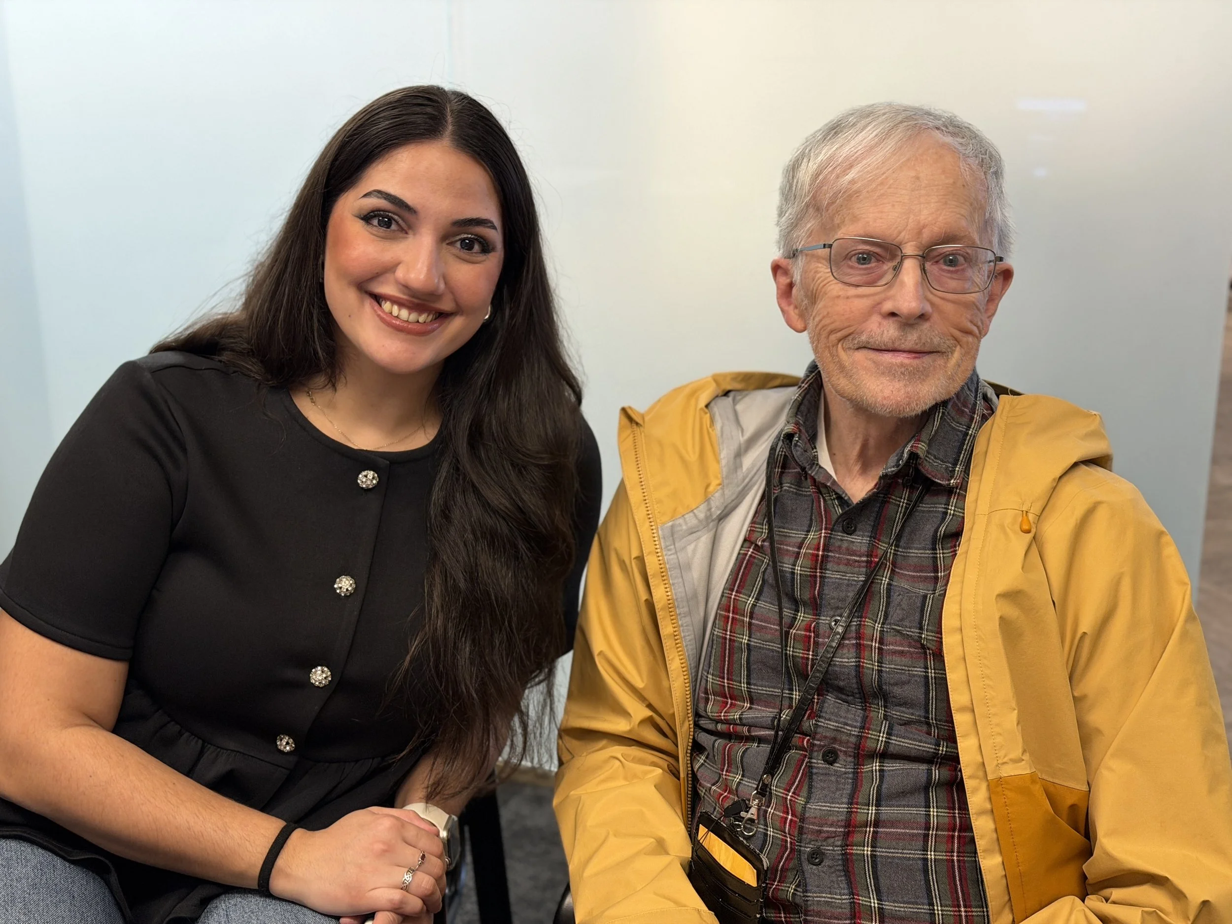 Two people smiling together indoors.