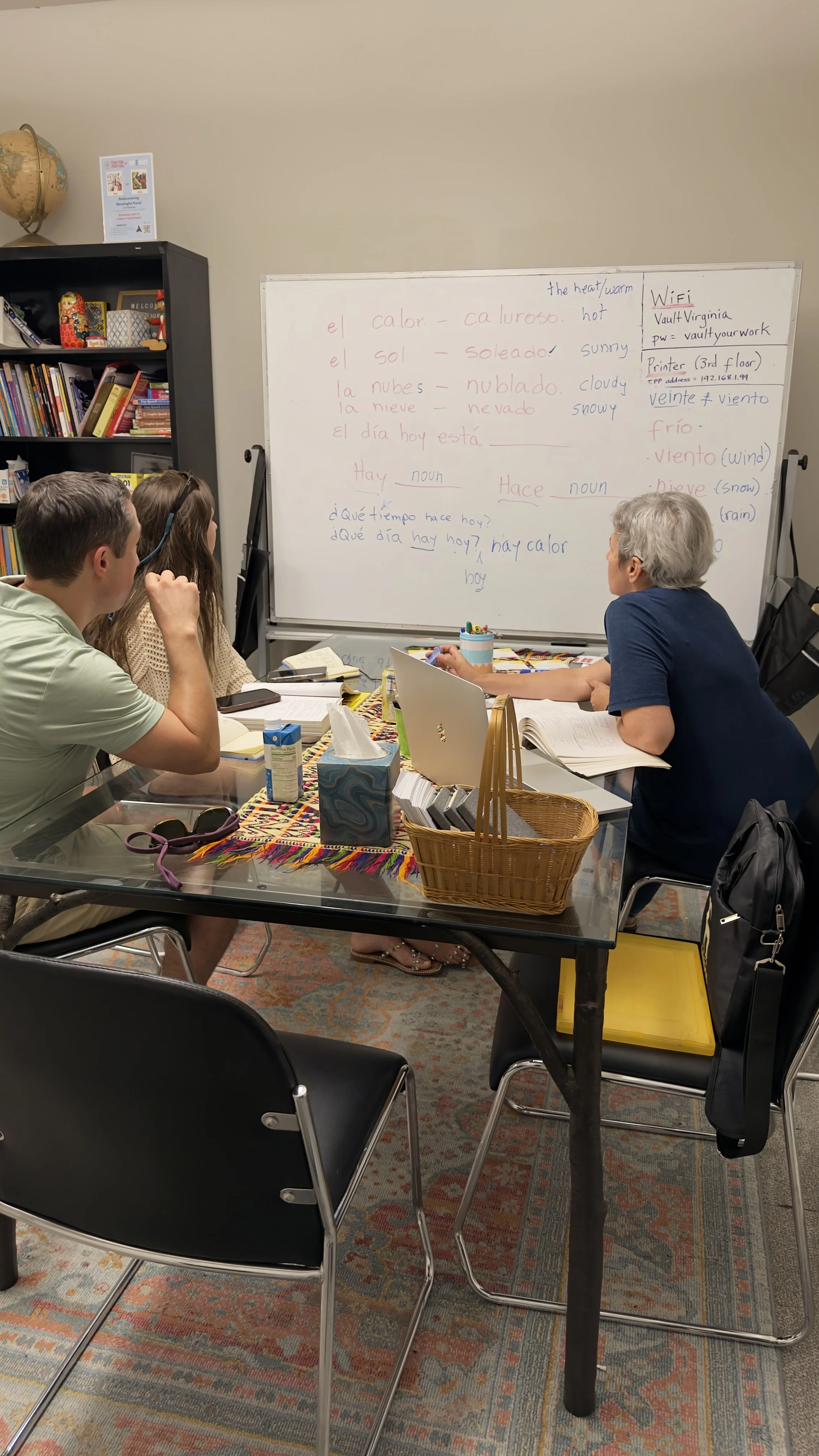 Adults working with notebooks during a Spanish lesson.