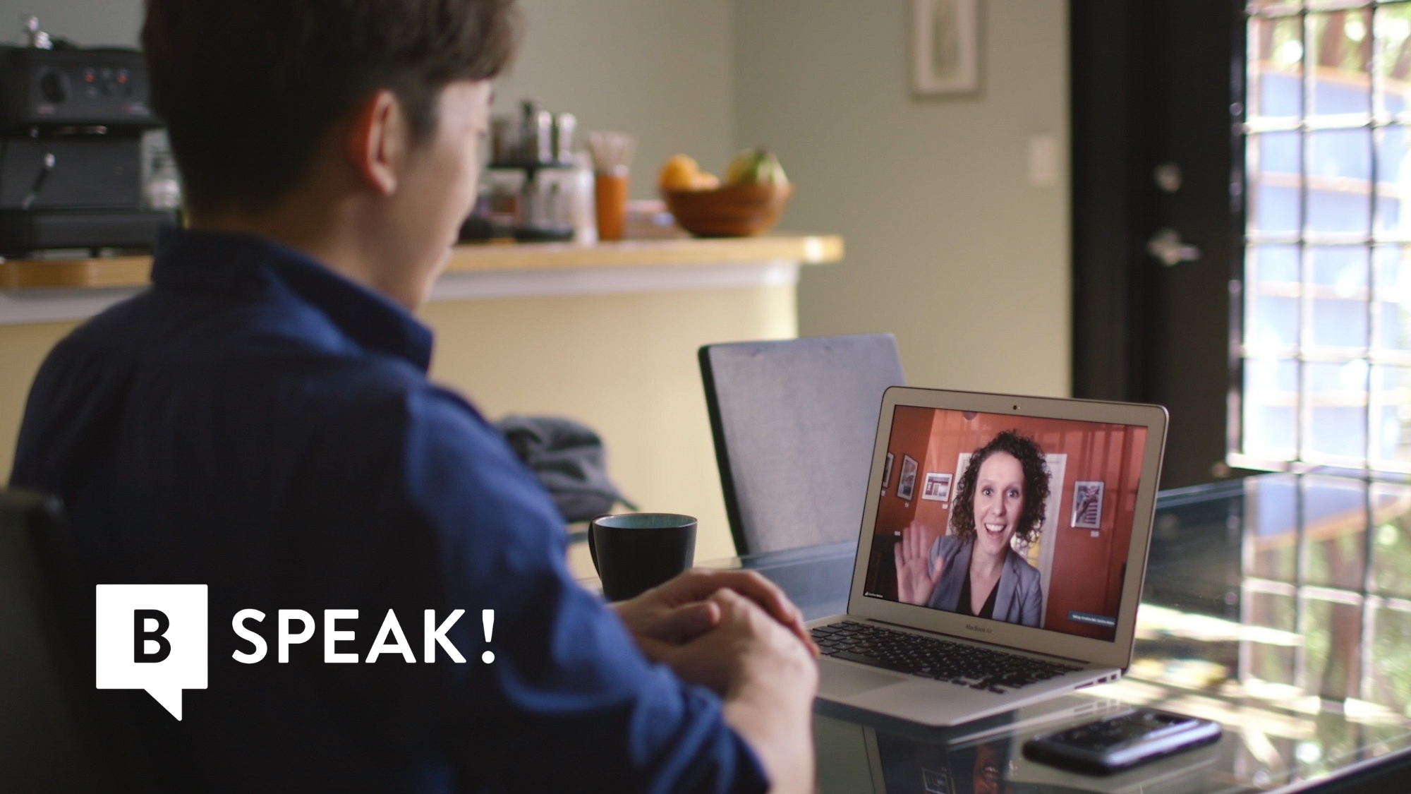 A learner speaking with a teacher on a laptop video call.