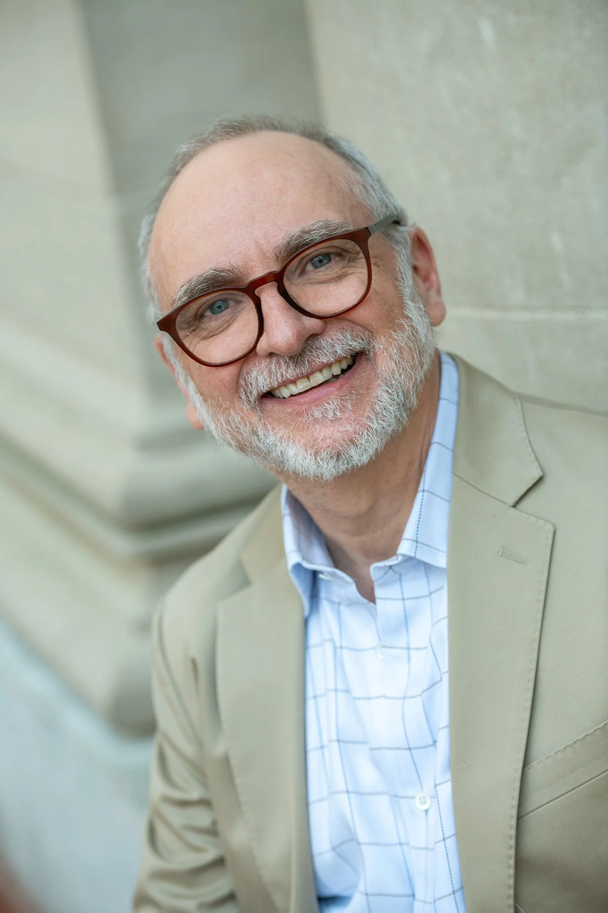 Portrait of a smiling man with glasses and a beard.