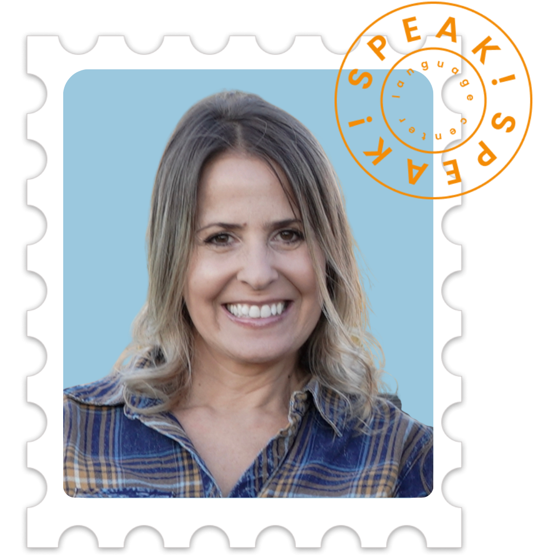 A woman smiling, with shoulder-length blonde hair, wearing a plaid shirt, in front of a light blue background, depicted as a postage stamp.