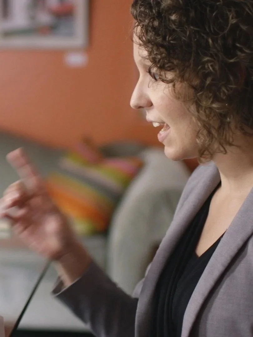 A woman speaking and gesturing during a conversation.