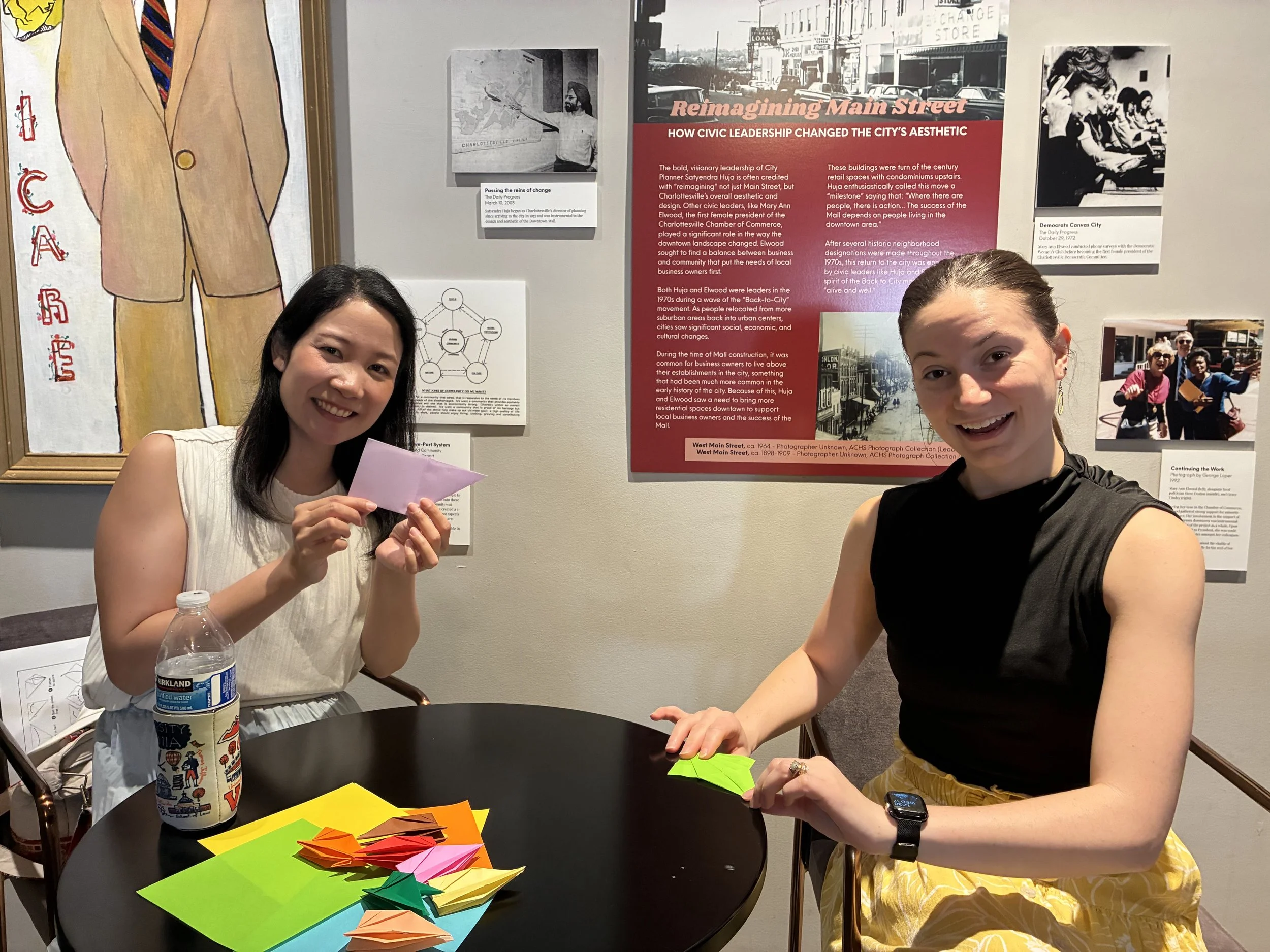 Two women folding paper during an arts activity.