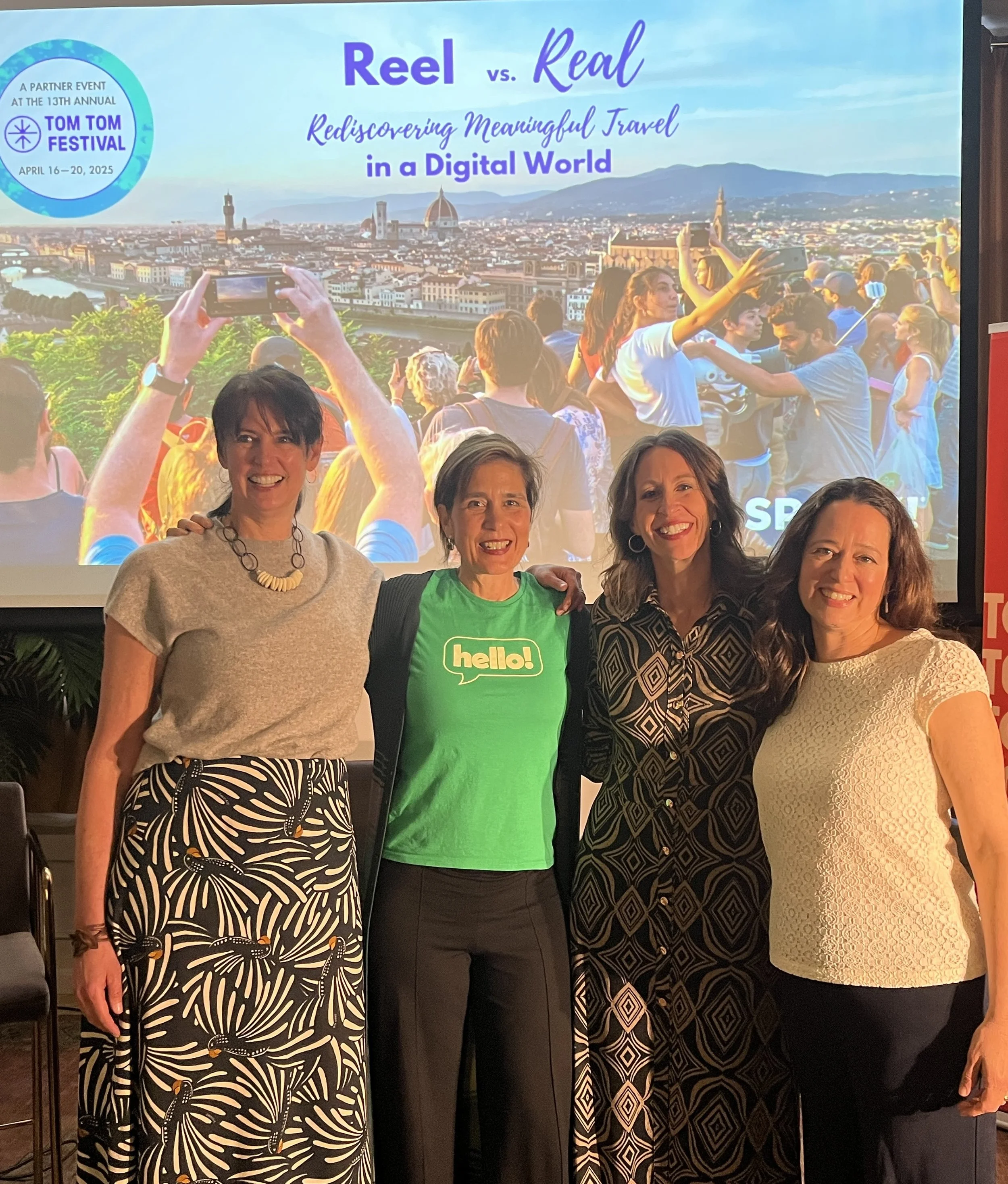 Women posing beside a presentation about meaningful travel.