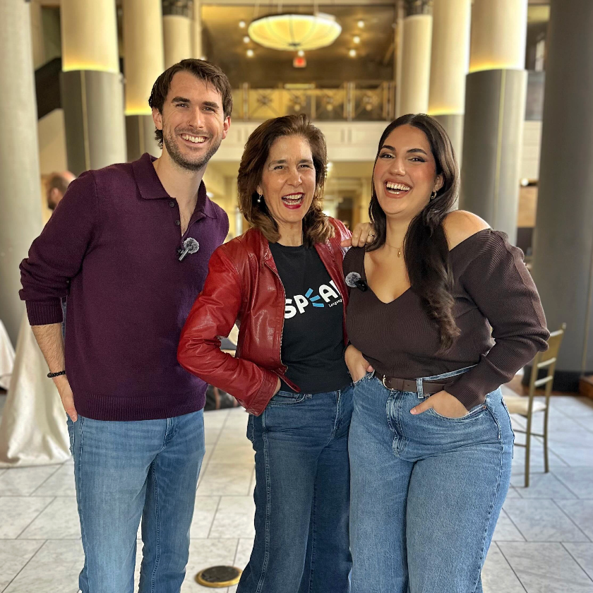 Three people smiling together indoors.