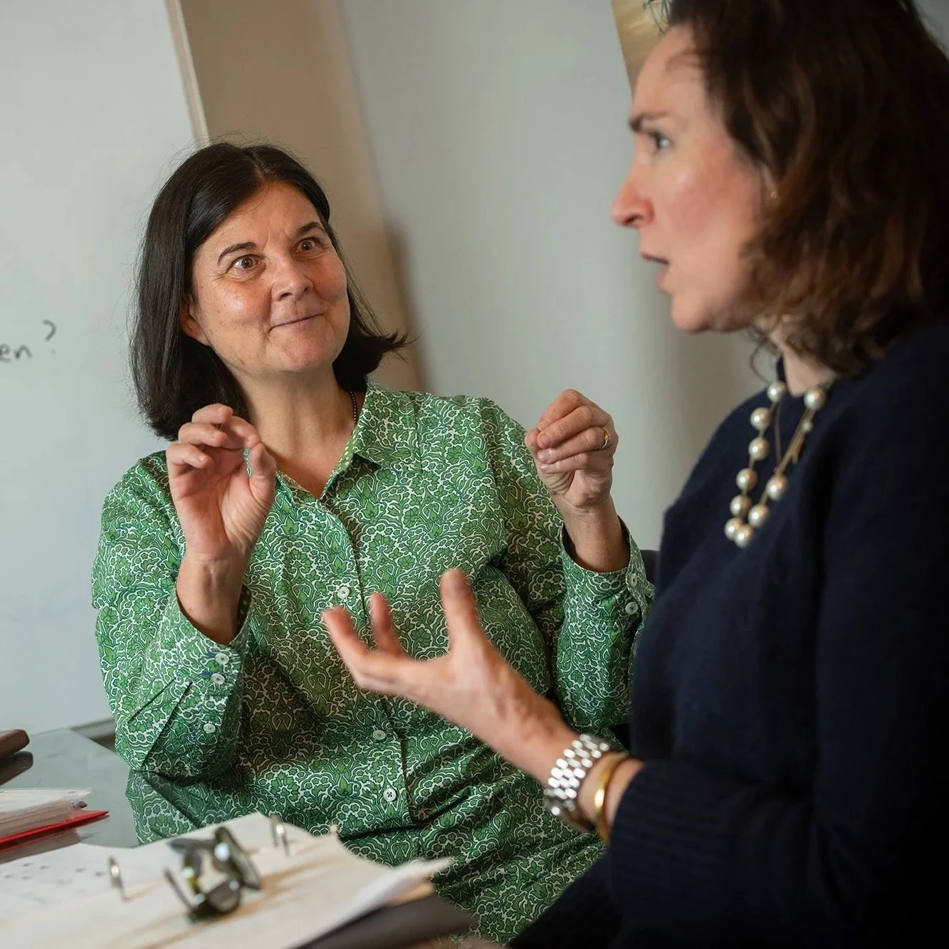 Two women talking and gesturing during a conversation.