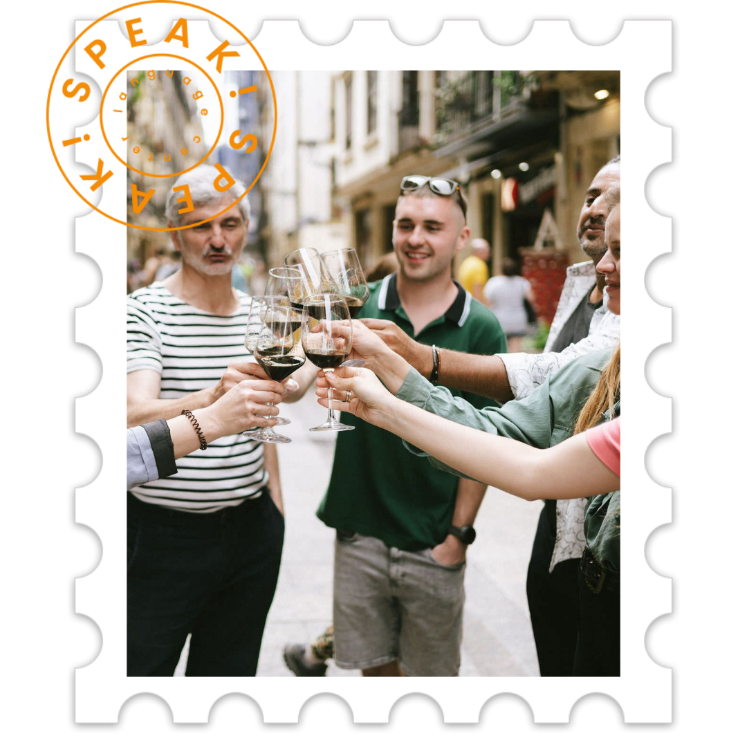 Group of friends celebrating with red wine glasses clinking in an outdoor urban setting.