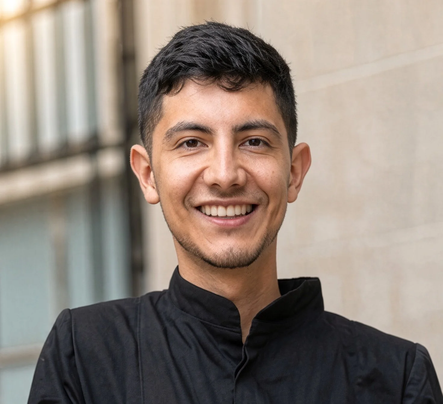 A smiling man standing outside a building.