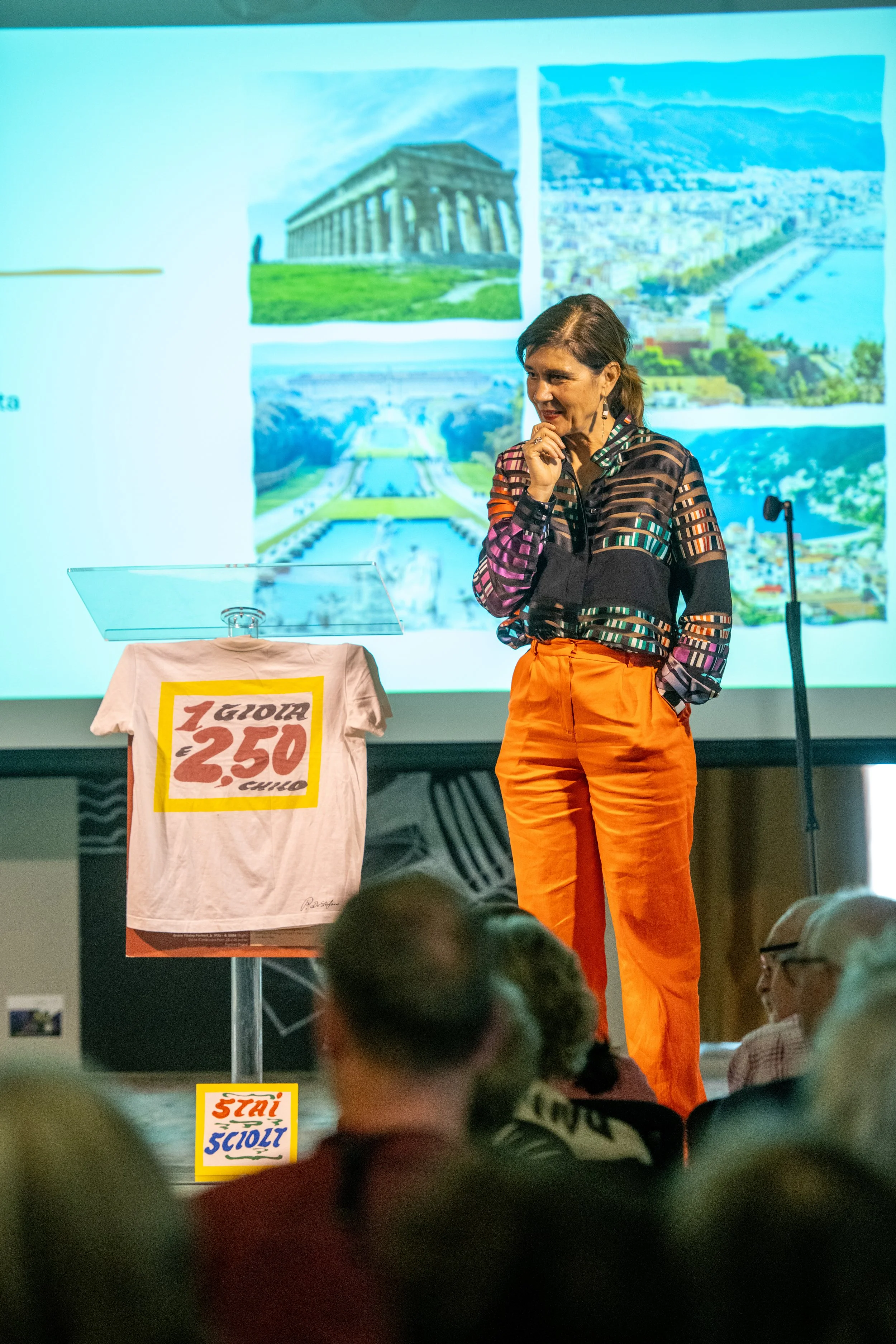 A speaker giving a presentation with travel photographs.