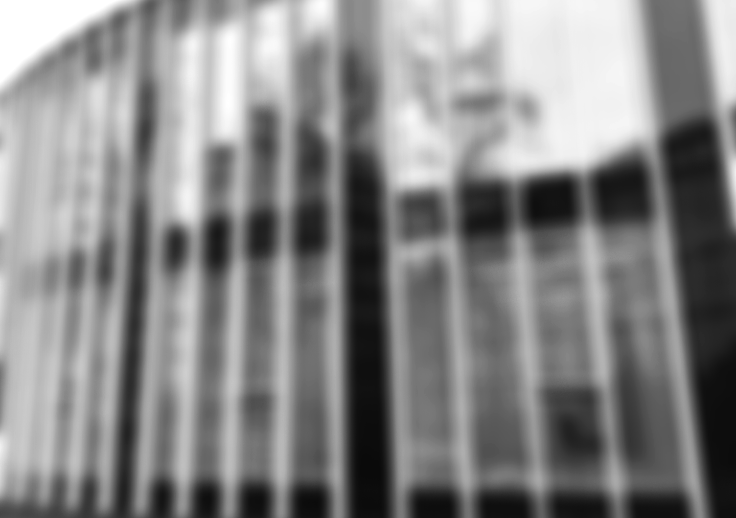 Die Fassade eines modernen Gebäudes mit großen Fenstern aus Glas. Es ist eine städtische Architekturansicht in Schwarz-Weiß.