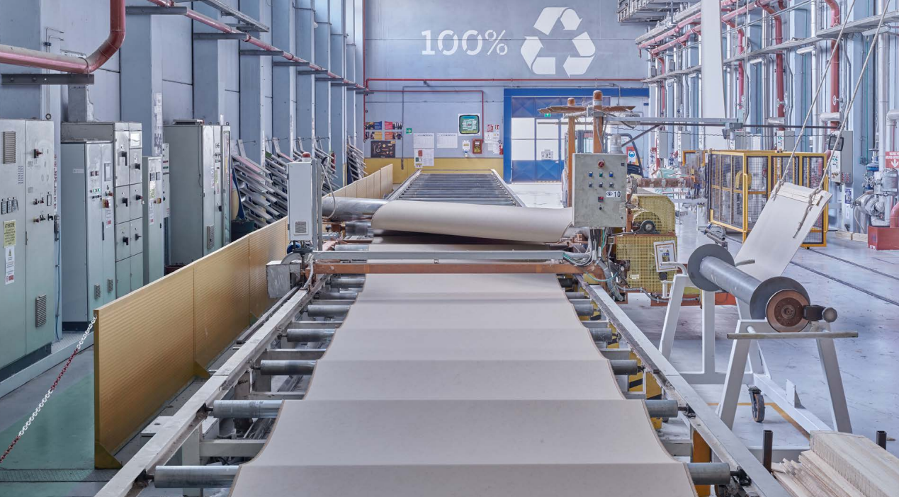 Macchinari industriali in una fabbrica con un nastro trasportatore che trasporta tessuto o carta