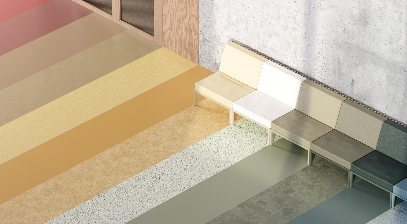 Una fila di sedili colorati in diverse tonalità disposti lungo un muro di cemento, con un pavimento multicolore a mattonelle.