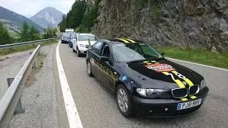 Line of police cars parked on the side of a mountain road with rocky cliffs and trees