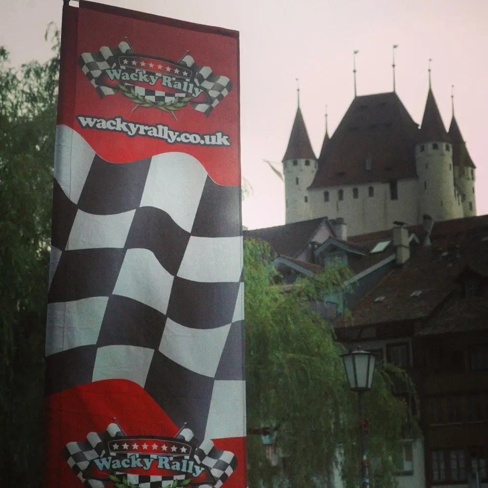 Flag for the Wacky Rally, featuring a checkered pattern and the website wackyrally.co.uk, with a castle in the background.
