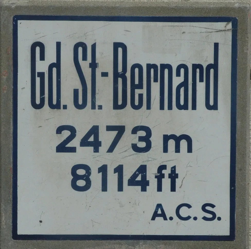 Street sign for Gd. St. Bernard indicating a distance of 2,473 meters or 8,144 feet, with the letters A.C.S.