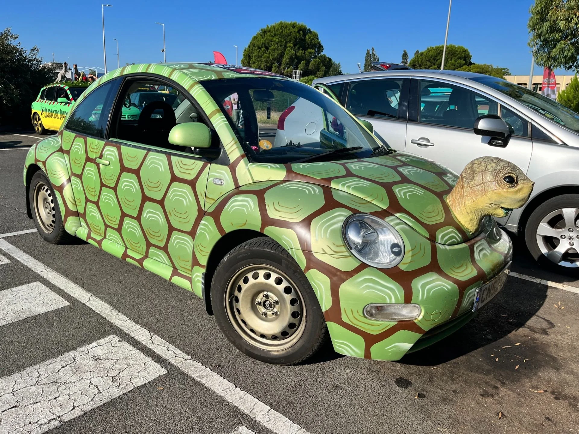 A car decorated with a turtle shell pattern and a turtle head on the front, resembling a turtle.