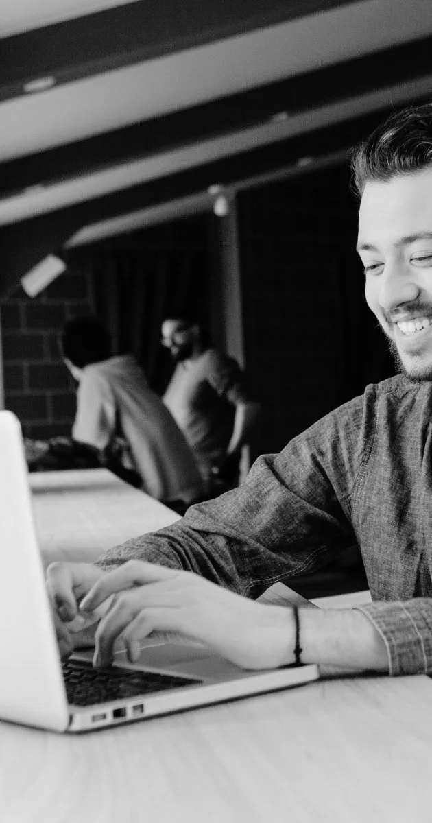 Image of a man smiling at his laptop