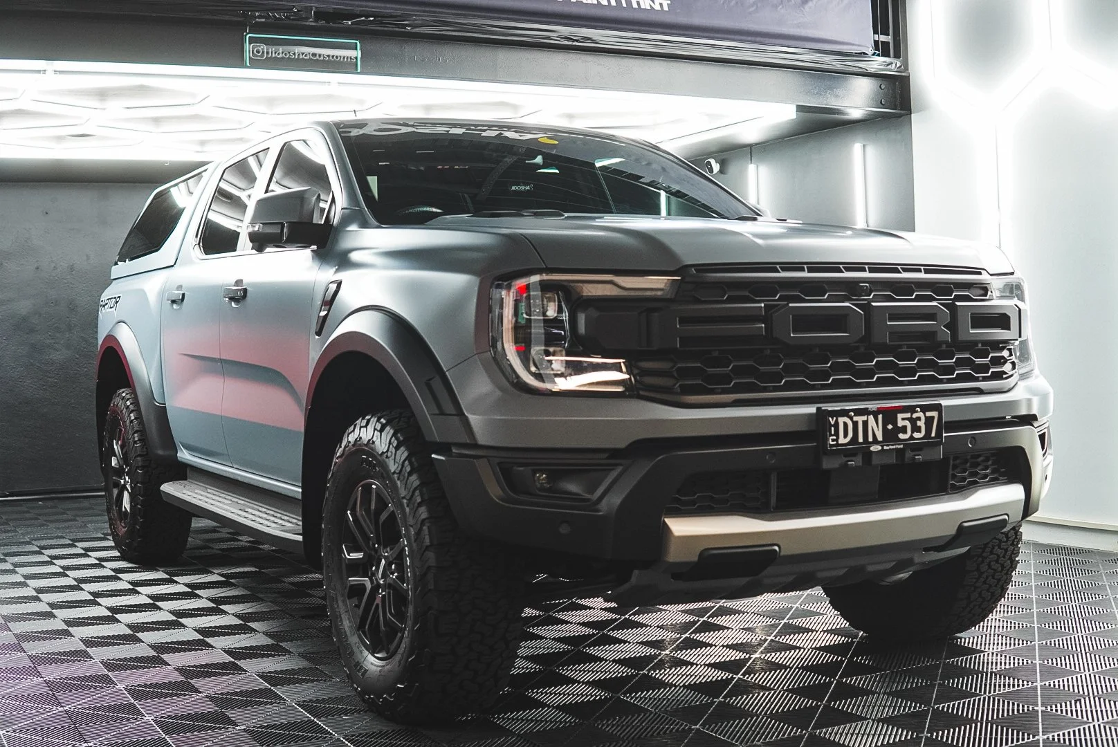 A silver Ford pickup truck inside Jidosha showroom