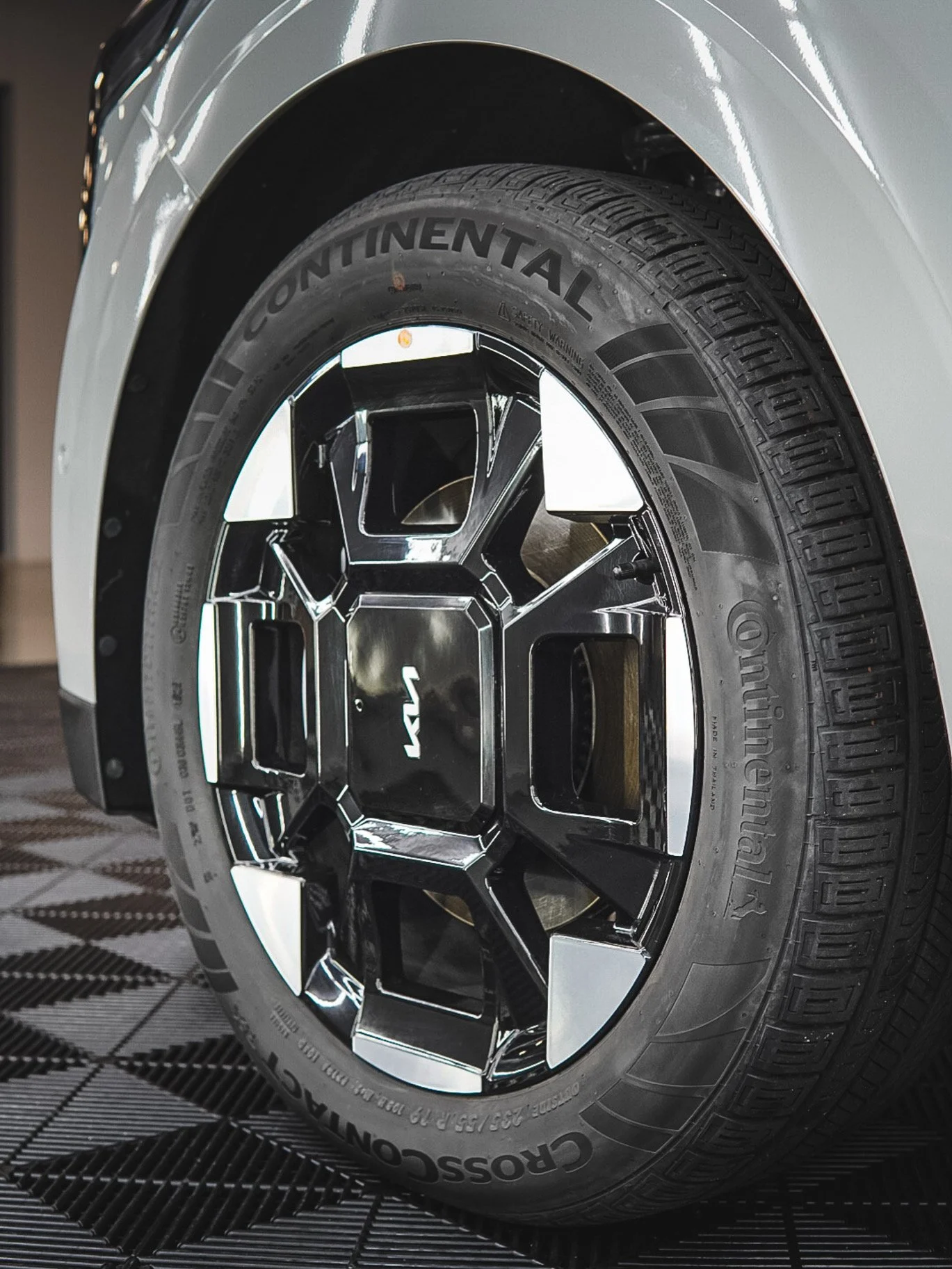 Close-up of a car tire with a black and silver rim, showing the tire brand 'Continental' and the car brand 'Lamborghini' logo on the hub in the center.