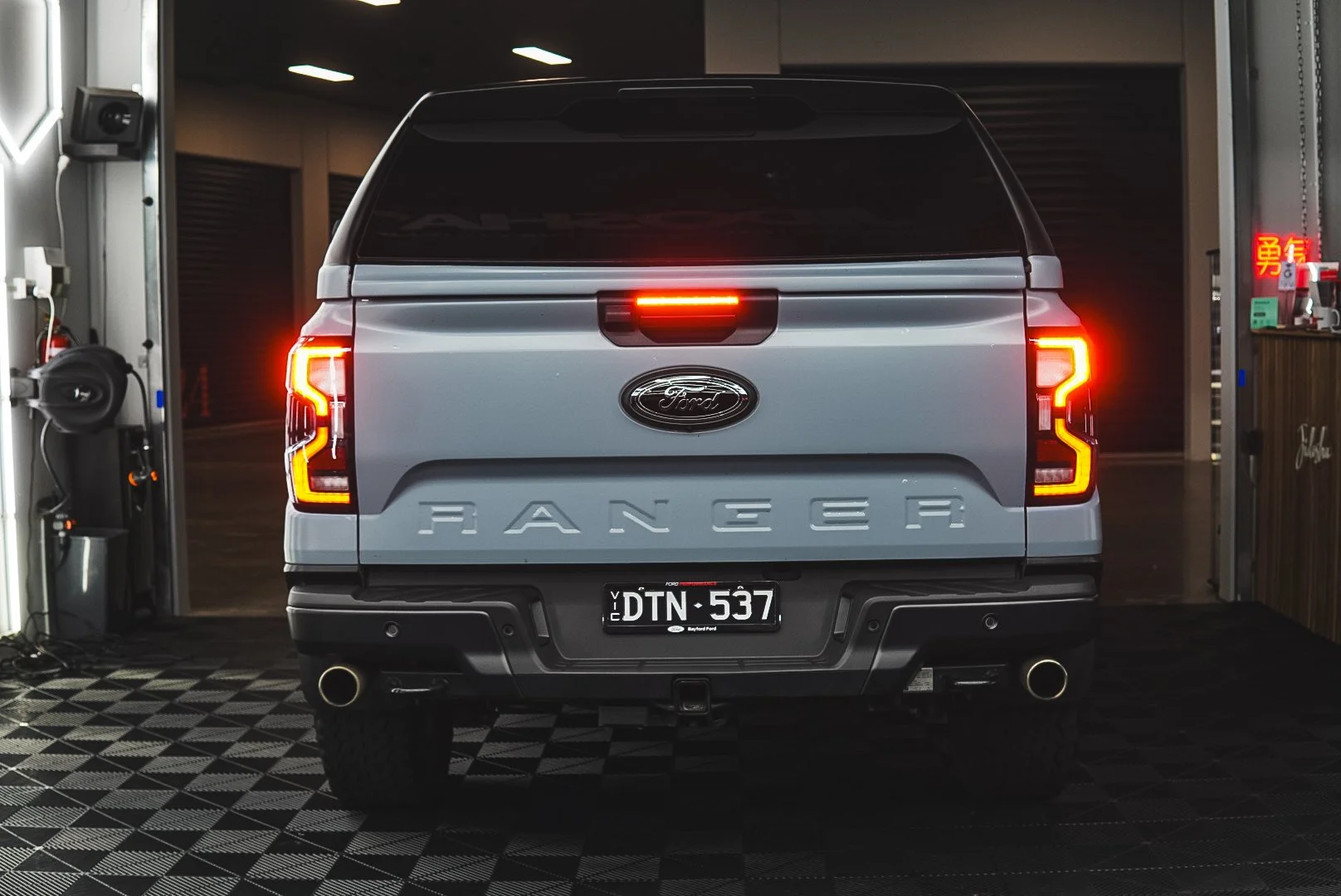 Rear view of a gray Ford Ranger pickup truck inside Jidosha garage