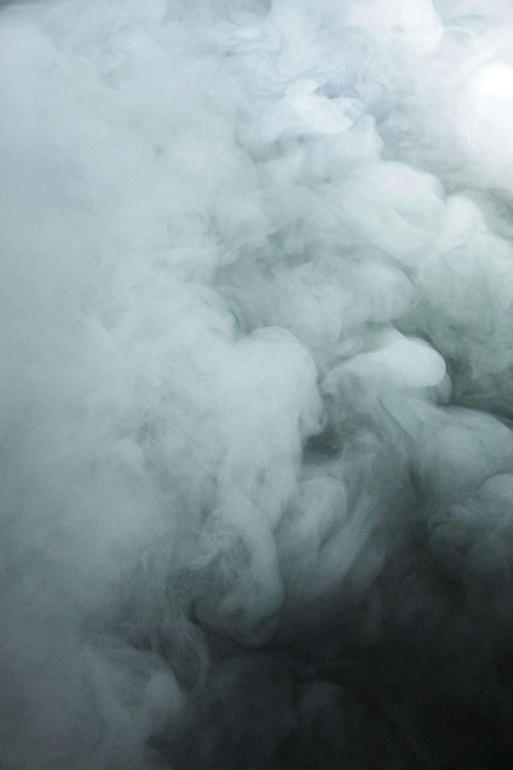 Close-up of swirling smoke or vapor with shades of gray and white.