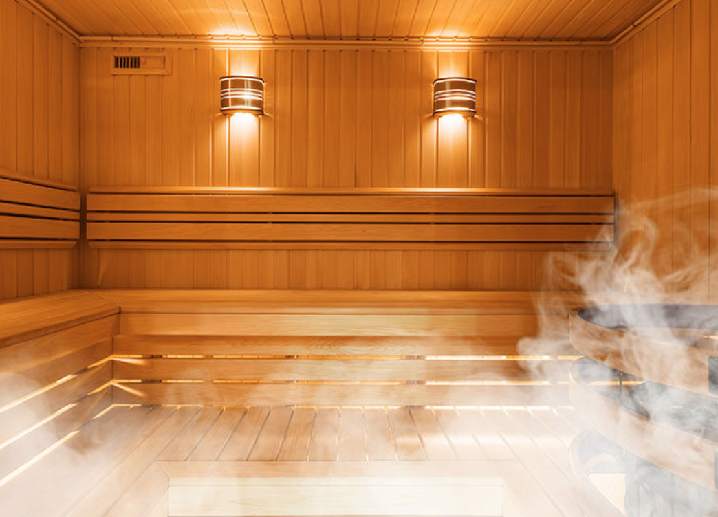 Interior of a traditional wooden sauna with steam and sauna stones.