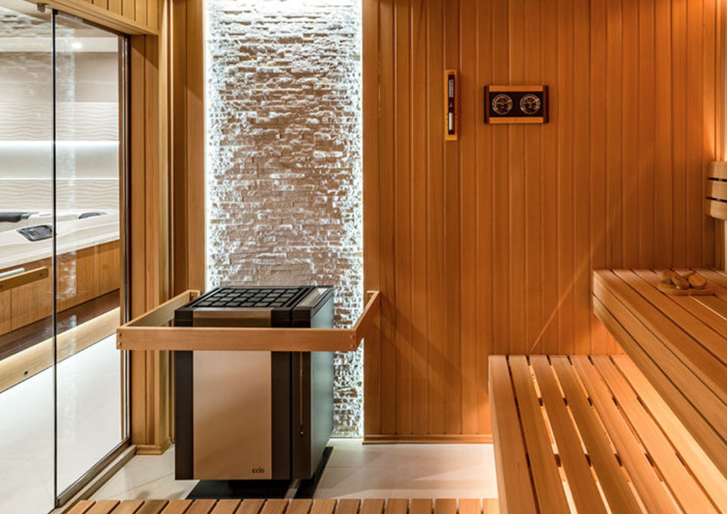 Interior of a sauna room with wooden benches, a wall heater, and a textured wall with backlighting.