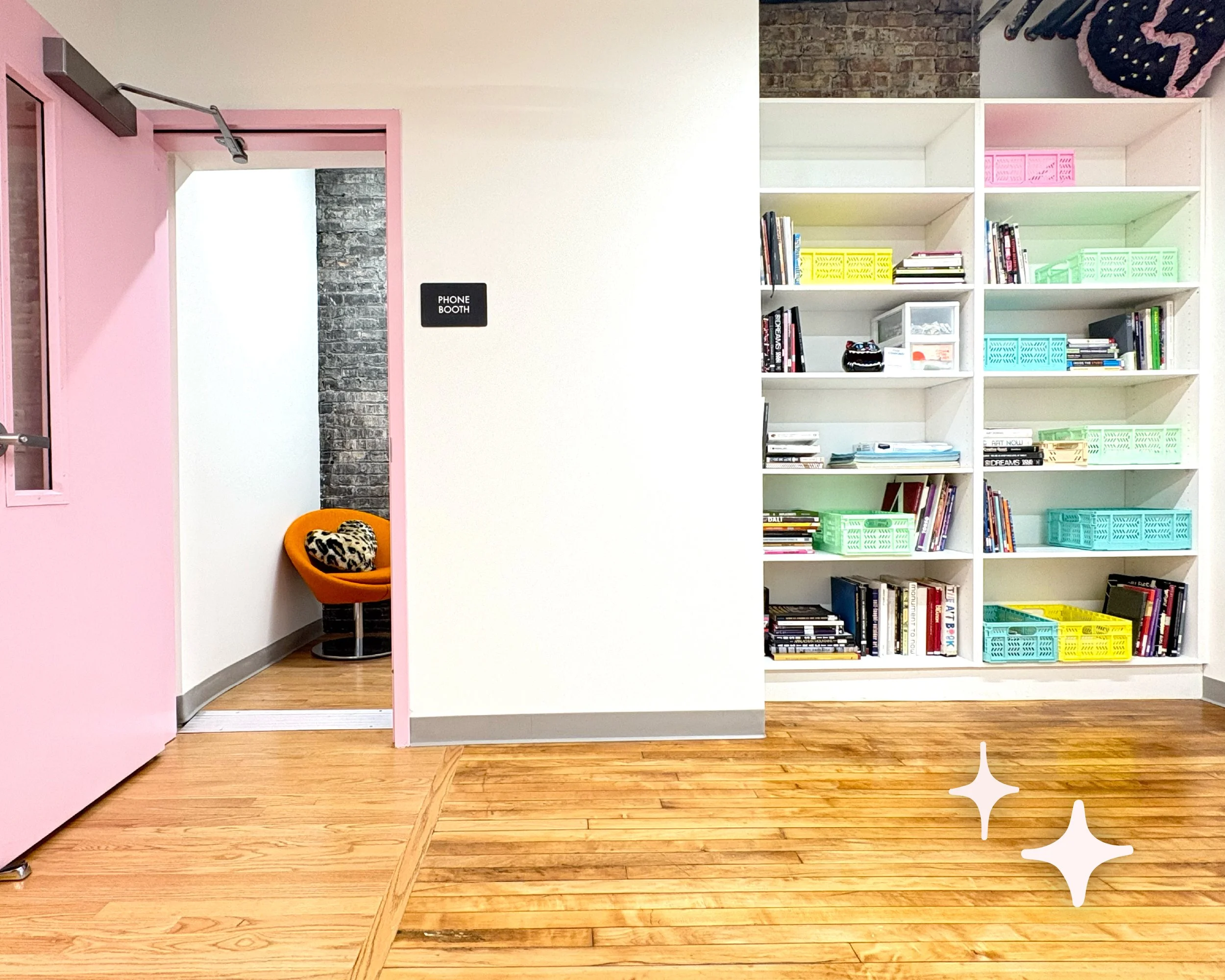 Another view of the hallway reveals a large bookshelf, and a "Phone Room" with a pink door. Inside sits an orange chair with a leopard print pillow.