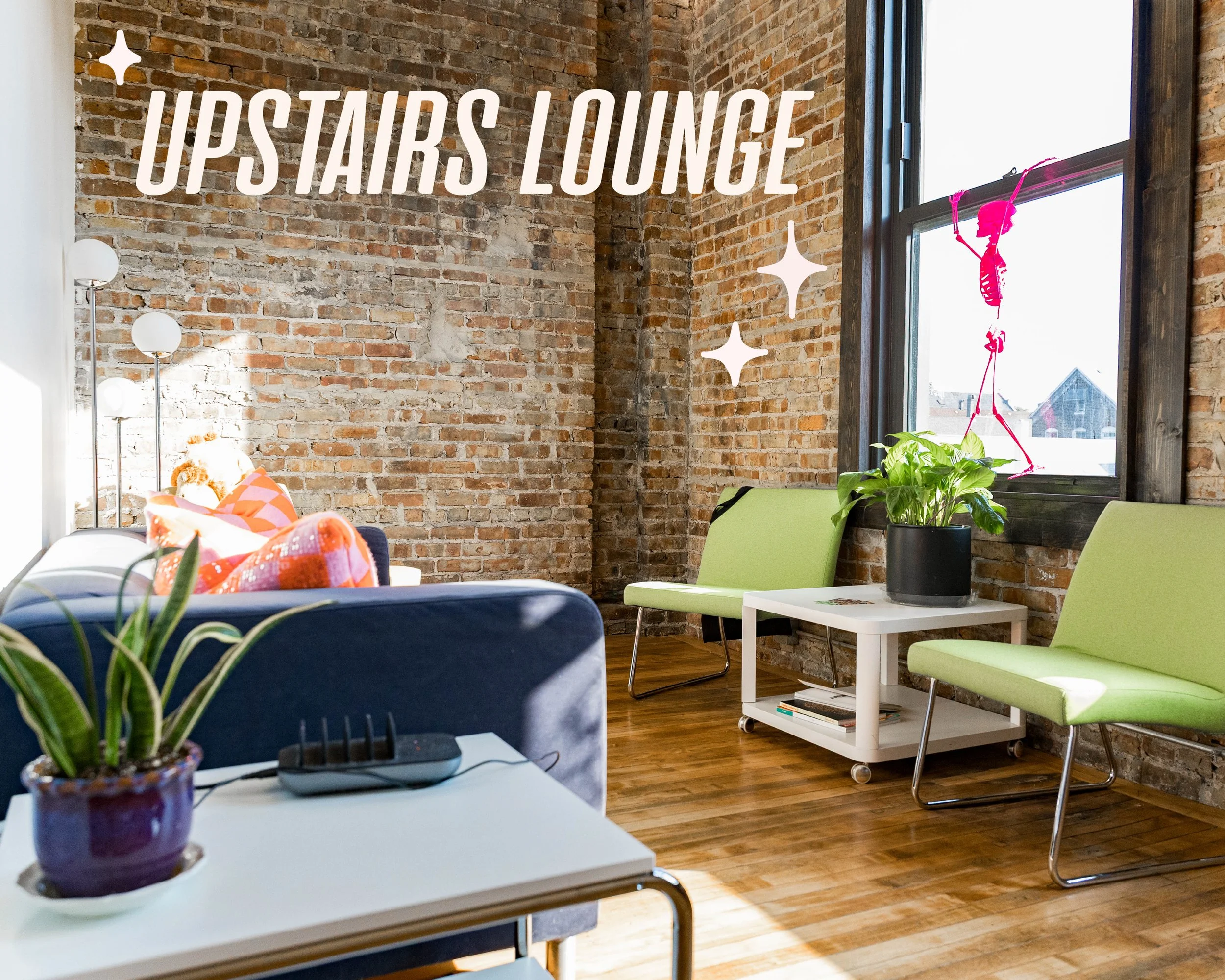 Graphic text reading "Upstairs Lounge" is overlaid on an image of a bright cozy space with a couch, phonecharging station, green upholstered chairs and plants.