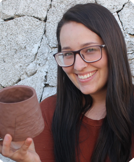 Handbuilt potter Bekah Bliss holding a clay pot.