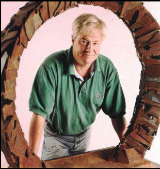 Metal sculptor Bob Doster looks through a large circular steel frame.