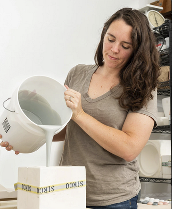Ceramic artist Stormie Burns pours casting slip into handmade molds in her pottery studio.
