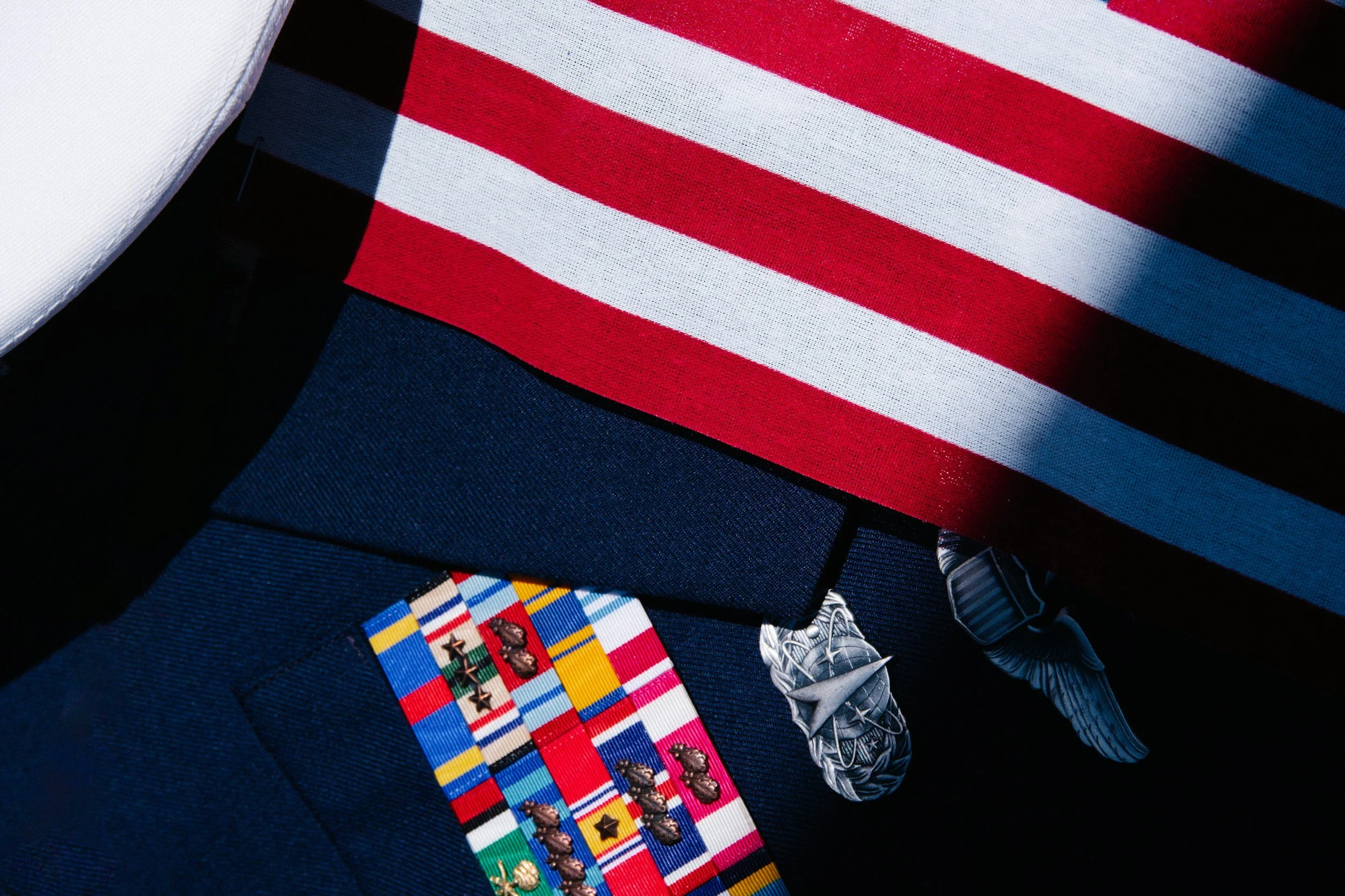 Close-up of a U.S. military uniform with medals and a patriotic American flag patch on the sleeve.