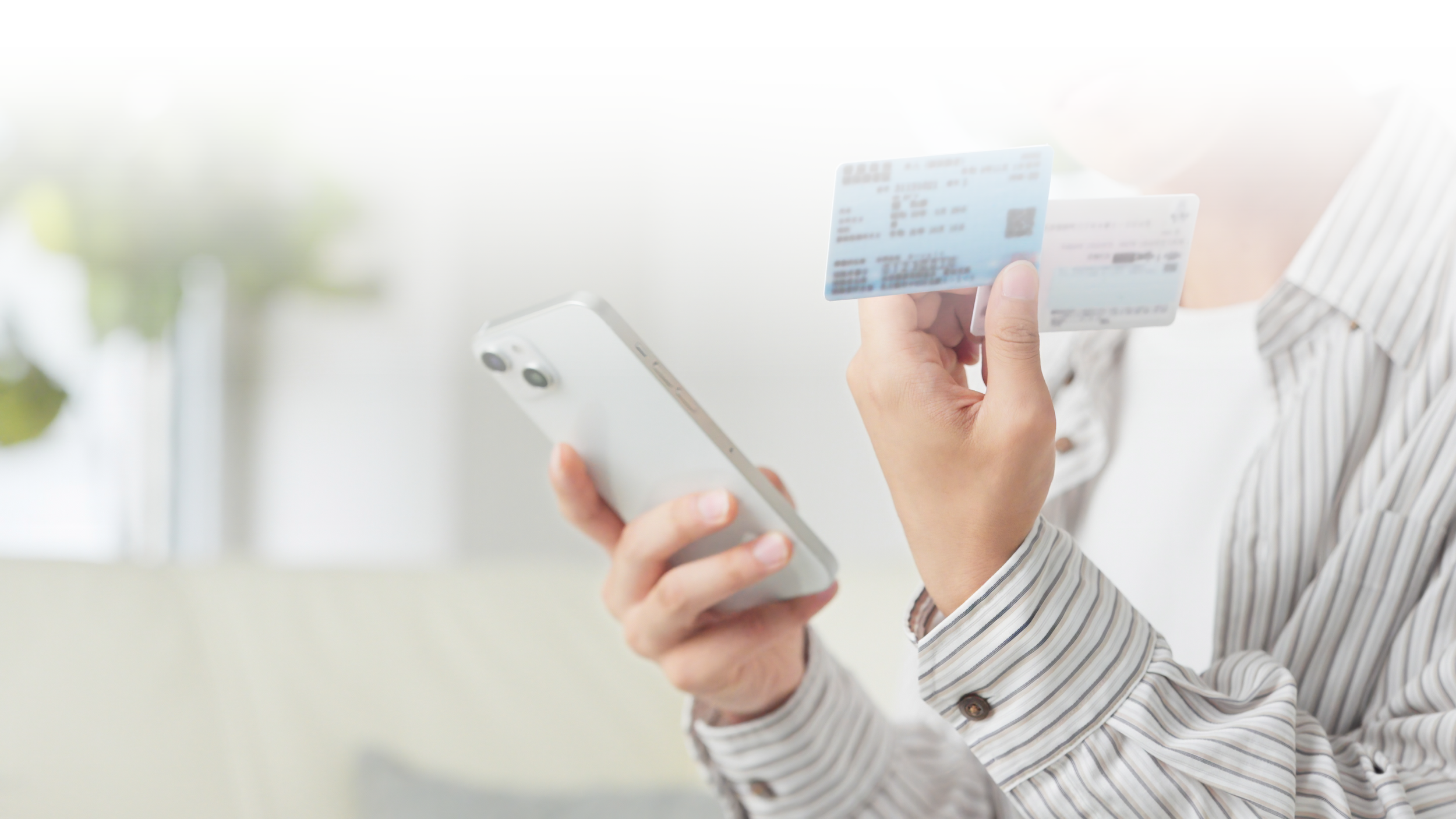 Person holding a smartphone and a blue credit card.