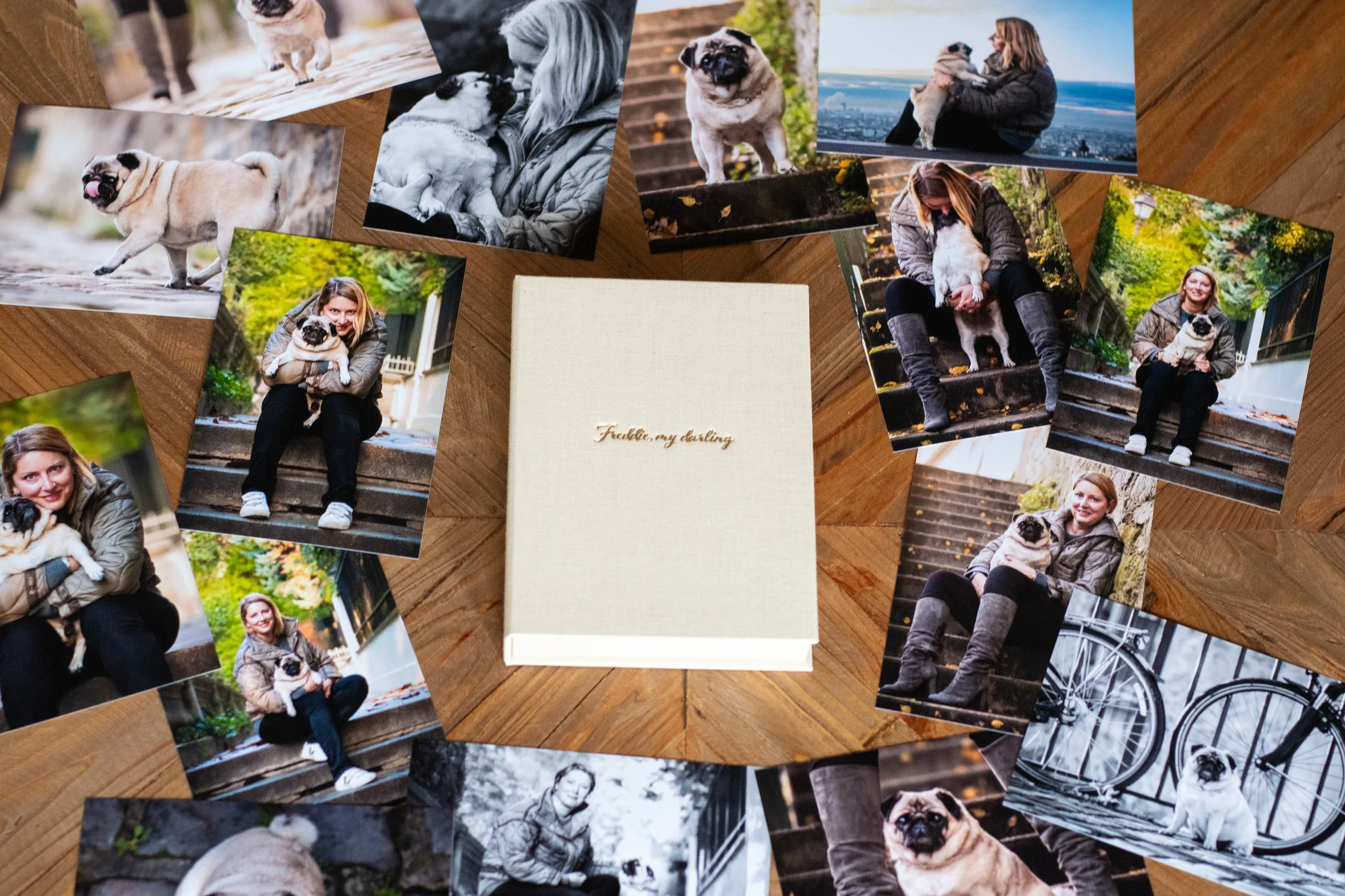Un coffret en lien avec inscription entouré de plusieurs tirages photo argentiques d'une personne avec son chien carlin, prises lors d'une sortie en ville au début de l'automne.